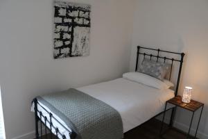 温彻斯特City Apartment的卧室配有一张床,墙上挂着一幅画