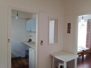 波罗斯Zontanos Studios & Apartments的白色的厨房配有桌子和镜子