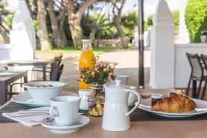 埃斯卡斯特利Hotel Rural Sant Joan de Binissaida的一张桌子,上面放着食物和一瓶橙汁