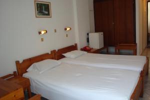 科斯镇卡里斯酒店的一间卧室配有一张带白色床单的大床