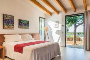 埃斯卡斯特利Hotel Rural Sant Joan de Binissaida的一间卧室设有一张床和一个大窗户