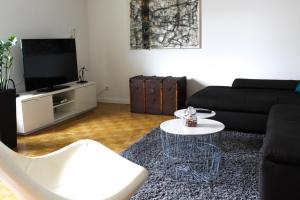 ChalampéGroßzügige helle Ferienwohnung bis 4 Personen in Chalampe, Elsass的客厅配有黑色沙发和桌子