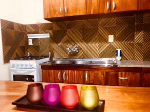 恩卡纳西翁德里奥公寓酒店 的厨房配有水槽和托盘上的五颜六色的碗