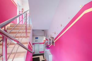 露米雅Pokoje Goscinne Oliwia & Laura I的一间设有粉红色墙壁和楼梯的房间