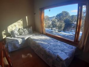 佩休尼亚镇Lago Mistico的一间卧室设有一张床和一个大窗户