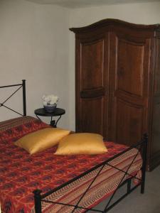 奥瓦达La Miseria的一张带两个枕头的床和木制橱柜