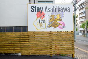 旭川Stay Asahikawa Koto的表示住在Asianatown的建筑上的标志