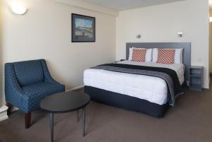 惠灵顿西广场酒店的一间卧室配有一张床、一把椅子和一张桌子