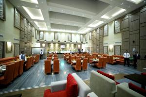 班加罗尔Rg皇家酒店的一间大房间,配有桌椅,里面的人