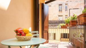 博洛尼亚Residenza Ariosto by Studio Vita的坐在阳台上桌子上的一篮水果