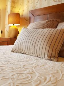 圣马尔廷德尔卡斯塔尼亚尔CASA RURAL VERSOS的一间卧室配有一张床、一盏灯和床罩