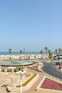 特拉维夫Liber Tel Aviv Sea Shore Suites BY RAPHAEL HOTELS的享有棕榈树海滩和大海的景色