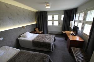 RokuaHotel RokuanHovi的酒店客房配有两张床和一张书桌