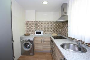 CorduenteCASA RURAL MIRALTAJO的厨房配有水槽和洗衣机