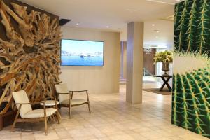 卡里拉KAKTUS Hotel Kaktus Playa - Adults Recommended的大堂设有椅子和墙上的大画作