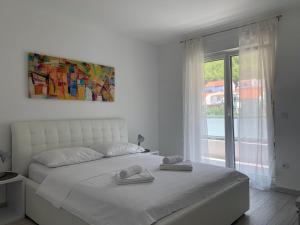 普罗马尼亚Apartments Danica的卧室配有白色的床和2条毛巾