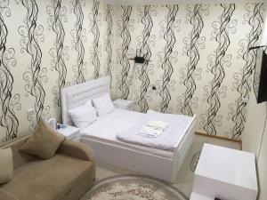 NinotsmindaHotel Triumph的小房间设有床和沙发