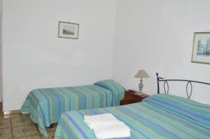 伊斯基亚波利托酒店的两张位于酒店客房的床,配有毛巾