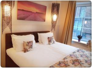 维尔纽斯Vivulskis Apart-Hotel的一间卧室配有带白色床单和枕头的床。