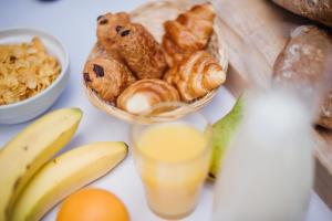 沙勒罗瓦DC Hotel Charleroi Airport的桌子上放着一碗面包和一杯橙汁