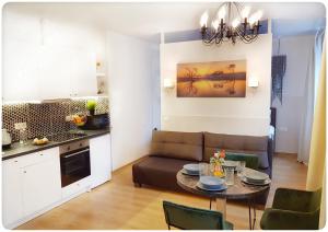 维尔纽斯Vivulskis Apart-Hotel的厨房以及带桌子和沙发的客厅。