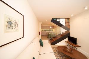 卡塞雷斯Apartamentos Habitavit en Cáceres的客厅设有白色沙发和楼梯。
