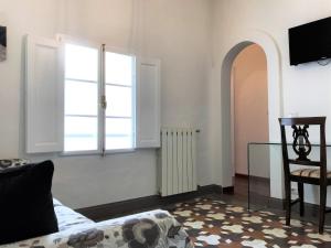 锡耶纳THE BLUE LODGE-cozy flat close to Piazza del Campo的客厅设有窗户和椅子