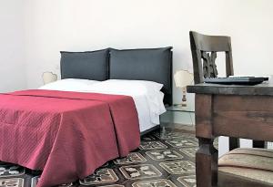 锡耶纳THE BLUE LODGE-cozy flat close to Piazza del Campo的一间卧室配有一张带红色毯子和椅子的床