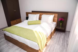 塞凡Garden Inn Resort Sevan的一间卧室配有一张带绿色枕头的大床