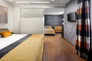 巴塞罗那威尔森精品酒店的一间酒店客房,配有一张床和一台电视