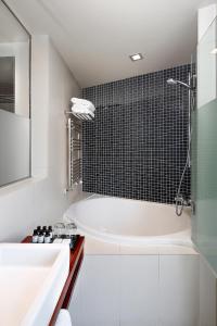 巴塞罗那威尔森精品酒店的白色的浴室设有浴缸和水槽。