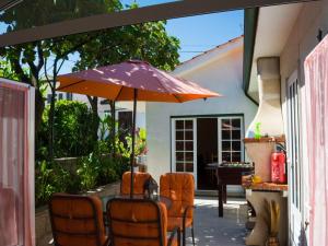 卡贝塞拉什德巴什图MyStay - Casa com Piscina em Cabeceiras de Basto的露台上的桌子和遮阳伞
