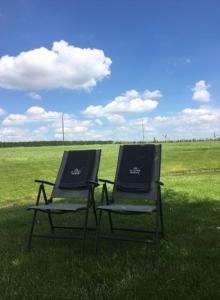 MoorsledeDe Kouterhoeve的两把椅子坐在草地上