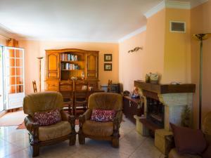 卡贝塞拉什德巴什图MyStay - Casa com Piscina em Cabeceiras de Basto的客厅配有两把椅子和壁炉