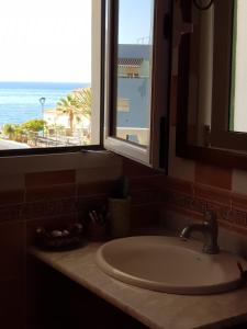 圣克鲁斯-德特内里费The Magic Dragonfly!的浴室水槽设有窗户,享有海景。