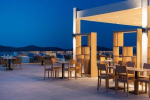伊罗达Elounda Breeze Resort的屋顶餐厅,配有桌椅