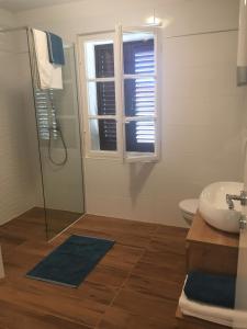 伊穆尼Stone & Salt Getaway Home的一间带水槽和卫生间的浴室以及窗户。