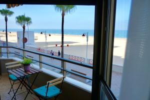 加的斯Victoria Beach Sunset Lounge的阳台享有棕榈树海滩的景致。