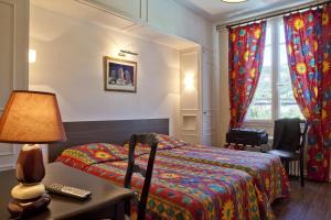 塞尔河畔维克德班酒店的一间卧室配有一张床和一张带台灯的桌子