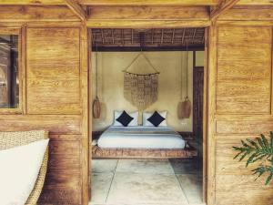 乌鲁瓦图Green Escape Eco Resort的木制客房内的一间卧室,配有一张床