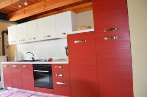 维莱内乌韦Holiday house with garden and enchanting view的红色的厨房配有白色橱柜和炉灶