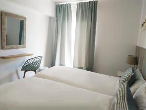 帕尔马诺瓦拉斯帕梅拉斯公寓的卧室配有床、椅子和窗户。