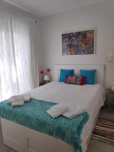 法鲁The Sunny Cottage的卧室配有带蓝色枕头的大型白色床