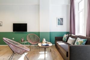 雅典雅典卫城景精品中央公寓的客厅配有沙发和两把椅子