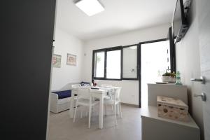 新福卡Casa vacanza Il Tramaglio的白色的厨房配有白色的桌子和椅子
