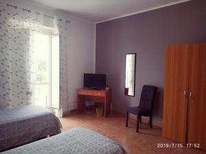 拉默齐亚泰尔默Santa e Maria Affittacamere的一间卧室配有一张床、一张书桌和一个窗户。