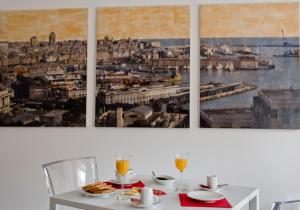 热那亚Genova46 Suites & Rooms的墙上有两幅画作的白色桌子