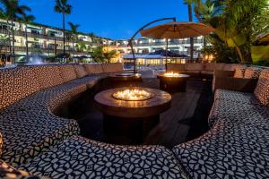恩塞纳达港圣尼古拉斯赌场酒店的庭院设有火坑、椅子和遮阳伞
