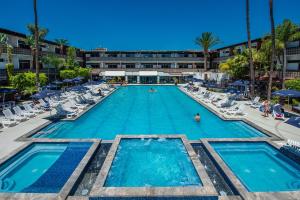 恩塞纳达港圣尼古拉斯赌场酒店的一个带椅子的大型游泳池和一间酒店