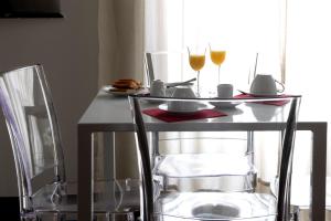 热那亚Genova46 Suites & Rooms的一张桌子,两杯葡萄酒和两把椅子